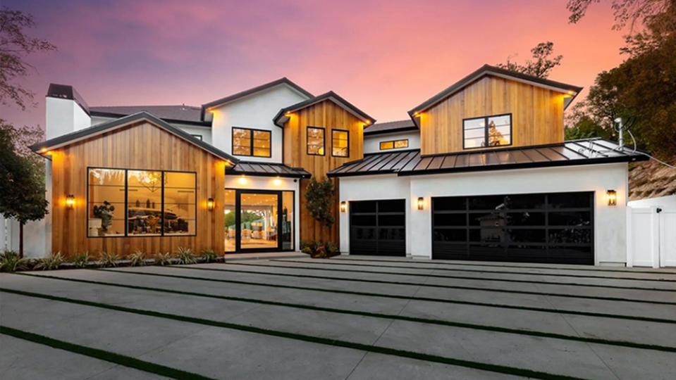 The front of the home featuring a smooth stone driveway, garage and its wooden accents. - Credit: Redfin