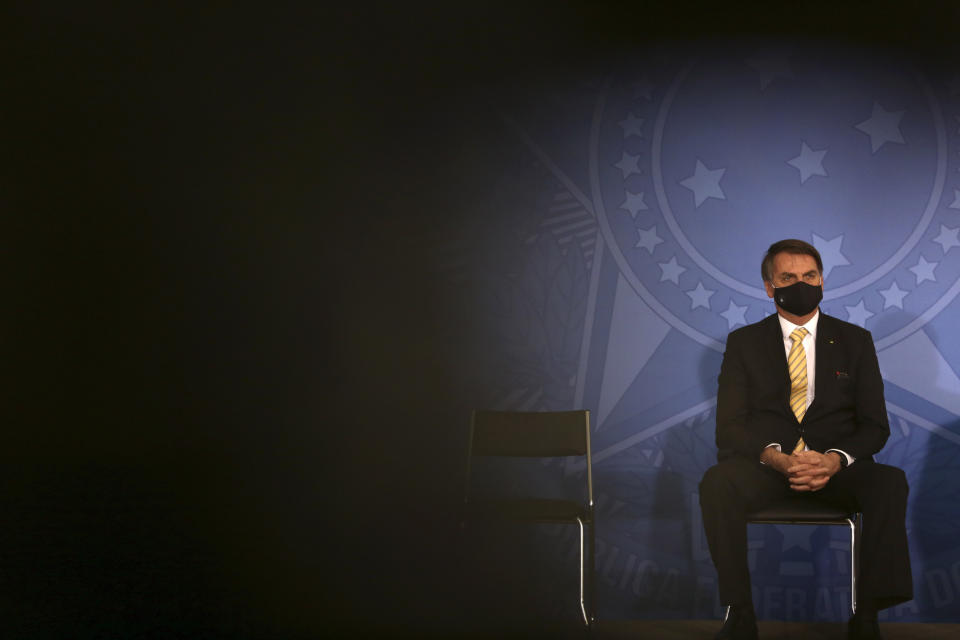 Brazil's President Jair Bolsonaro wears a mask amid the COVID-19 pandemic during an event promoting a government campaign against domestic violence at Planalto presidential palace in Brasilia, Brazil, Friday, May 15, 2020. (AP Photo/Eraldo Peres)