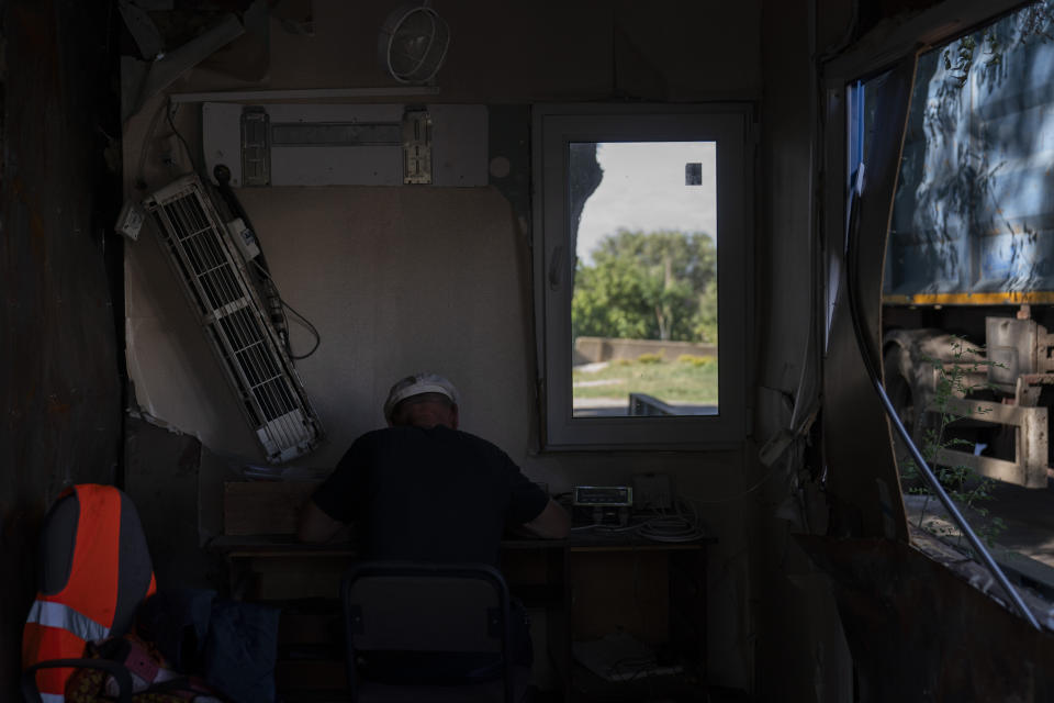 An employee works in an office partially damaged in Russian missile attacks at a grain facility in Pavlivka, Ukraine, Saturday, July 22, 2023. (AP Photo/Jae C. Hong)