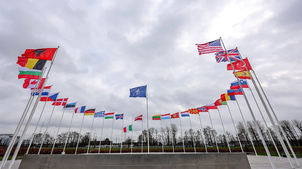 Flags of NATO member countries flap in the wind outside NATO headquarters in Brussels