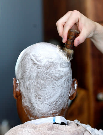 FILE PHOTO: Cream is applied on a client at the Bespoken Man, a full-service gentleman's barber shop in Sandton, South Africa, December 14, 2018. REUTERS/Siphiwe Sibeko