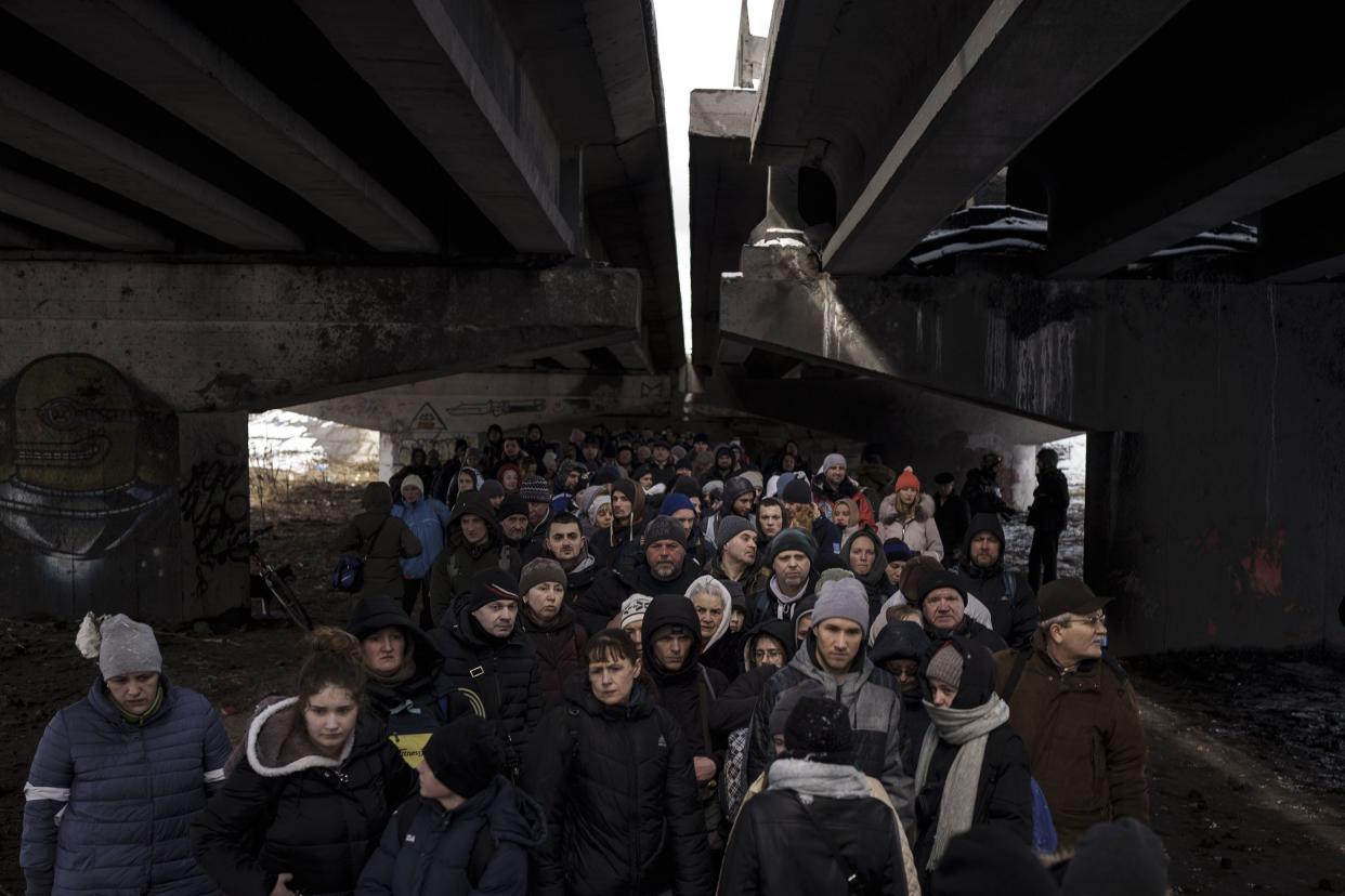 Ukrainians crowd under a destroyed bridge as they try to flee crossing the Irpin river in the outskirts of Kyiv, Ukraine, Tuesday, March 8, 2022. Demands for ways to safely evacuate civilians have surged along with intensifying shelling by Russian forces, who have made significant advances in southern Ukraine but stalled in some other regions. Efforts to put in place cease-fires along humanitarian corridors have repeatedly failed amid Russian shelling.