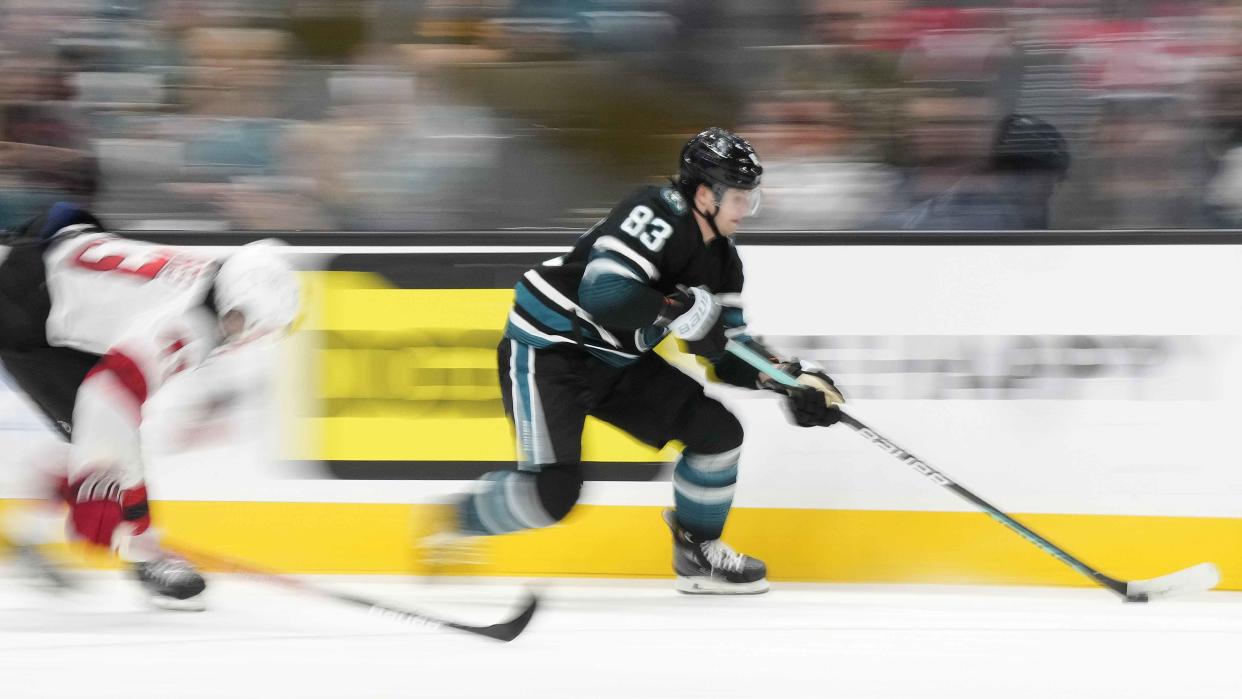  The San Jose Sharks move fast on a breakaway with a blurred background. . 