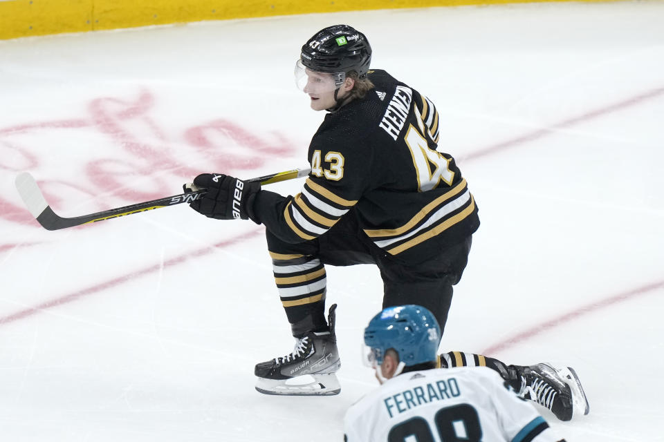 Boston Bruins left wing Danton Heinen follows through as he hits the puck into the net to score in front of San Jose Sharks defenseman Mario Ferraro (38) in the second period of an NHL hockey game, Thursday, Nov. 30, 2023, in Boston. (AP Photo/Steven Senne)