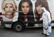 A municipal worker wearing protective gear sprays disinfectant to help prevent the spread of the coronavirus, on a street in Beirut, Lebanon, Tuesday, March 31, 2020. In Lebanon, a criminal court ordered the release of 46 prisoners who were being held without trial to protect them from getting infected, the state-run National News Agency reported. (AP Photo/Hussein Malla)