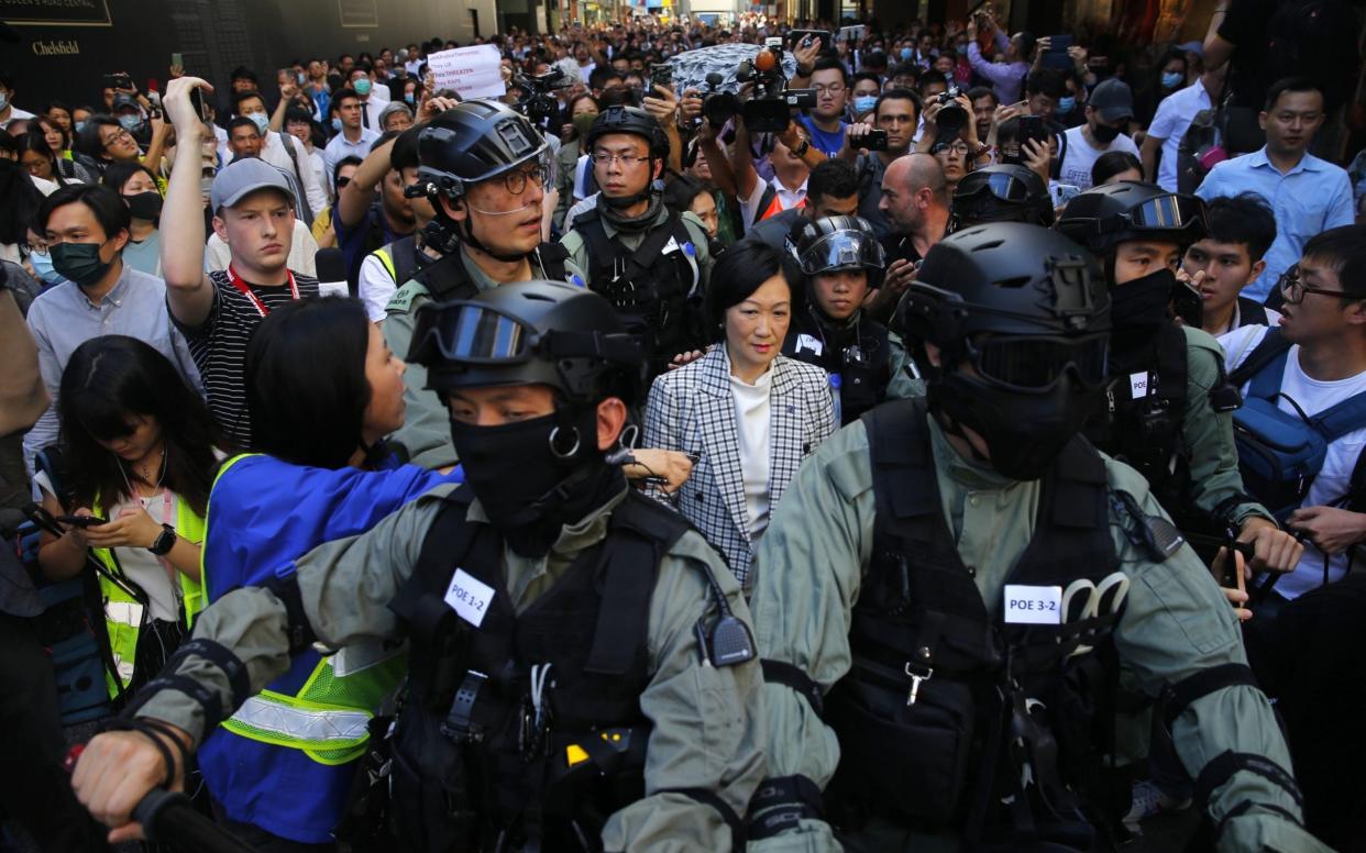 Prominent pro-Beijing law maker Regina Ip is escorted by police while surrounded by pro-democracy protesters - REX