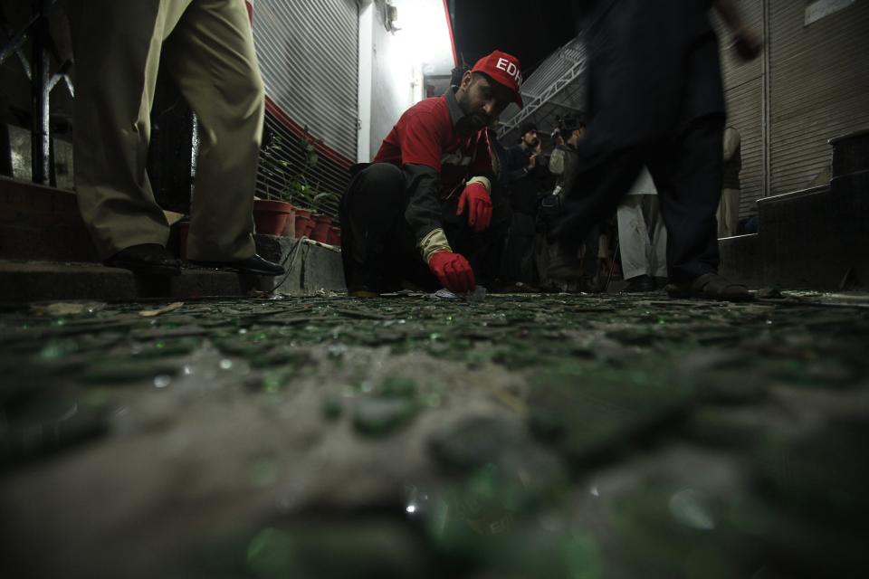 A rescue worker collects evidence at the site of a bomb blast in Peshawar