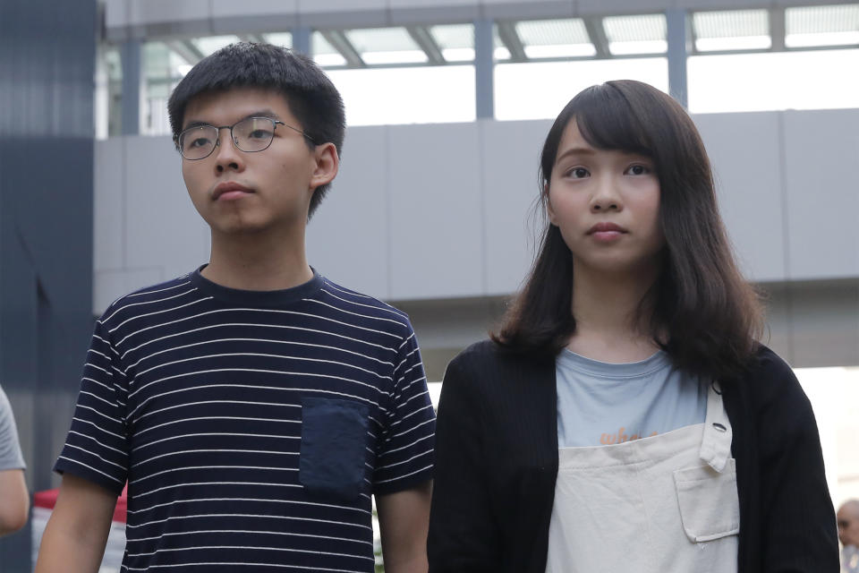 In this June 18, 2019, photo, pro-democracy activists Agnes Chow, right, and Joshua Wong meet media outside government office in Hong Kong. Demosisto, a pro-democracy group in Hong Kong posted on its social media accounts that well-known activist Joshua Wong had been pushed into a private car around 7:30 a.m. Friday, Aug. 30, 2019 and was taken to police headquarters. It later said another member, Agnes Chow, had been arrested as well. (AP Photo/Kin Cheung)