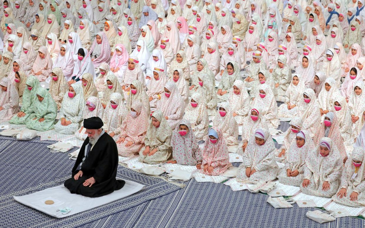 Iranian Supreme Leader Ayatollah ALI KHAMENEI prays during a Taklif celebration with a group of Muslim teenage girls in Tehran - Iranian Supreme Leader's Office/Zuma Press