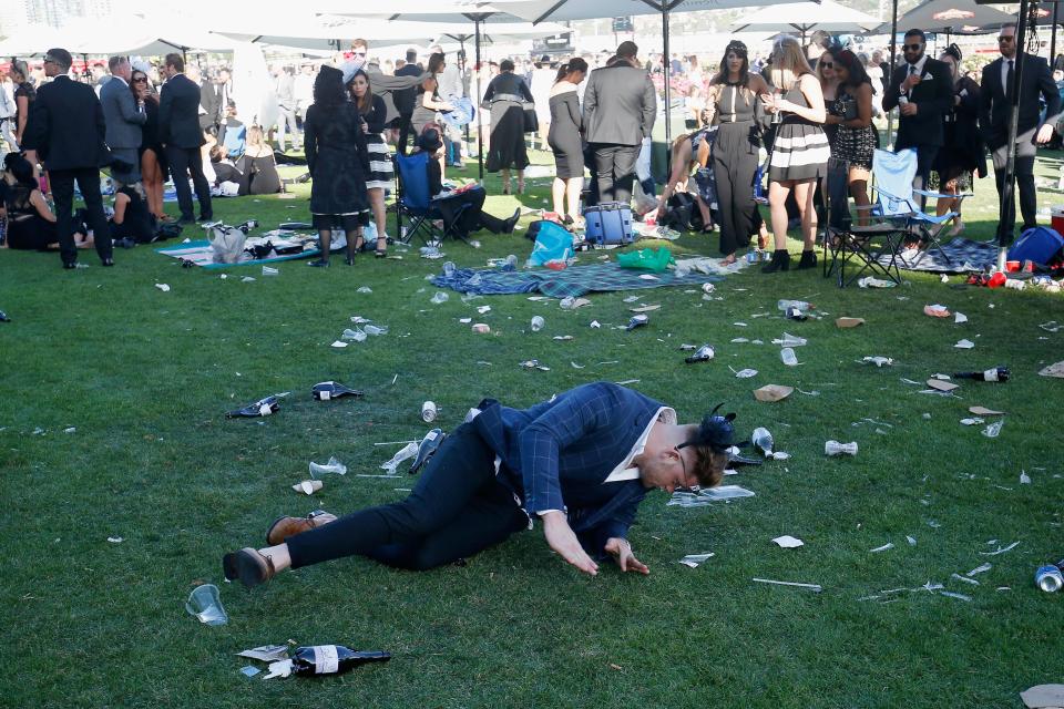 <p>One gentleman struggles to get up from the rubbish-strewn lawn.</p>