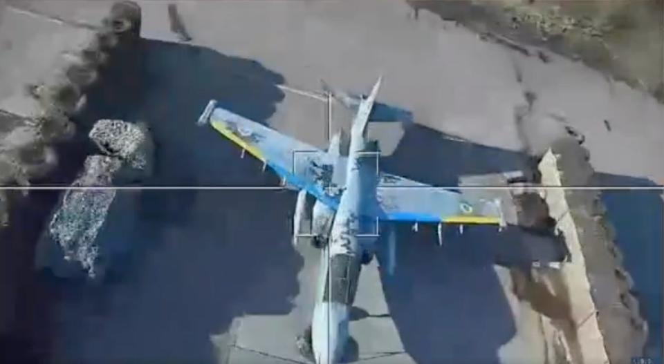 A screenshot from a video appearing to show a Russian Lancet drone attacking a decoy of a Ukrainian Su-25 jet.