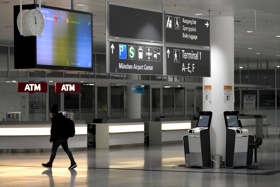 A man walks through deserted departure terminal during a strike in Bavaria at the airport in Munich, Germany, Sunday, March 26, 2023. An increased number of travelers in Germany boarded trains and planes on Sunday to avoid a massive one-day strike Monday that's supposed to bring the country's transport system to a standstill. But even advance travels were met with disruptions in some places as Munich airport already shut down Sunday due to the strike and technical problems at Lufthansa in Frankfurt led to flight delays and cancellations at the country's biggest airport. (AP Photo/Matthias Schrader)