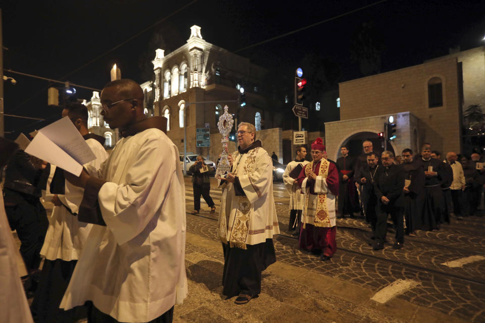 Christian clergymen carry a wooden relic believed to be from Jesus' manger outside the Notre Dame church in Jerusalem, Friday, Nov. 29, 2019. Christians are celebrating the return to the Holy Land of a tiny wooden relic believed to be from Jesus' manger nearly 1,400 years after it was sent to Rome as a gift to the pope. (AP Photo/Mahmoud Illean)