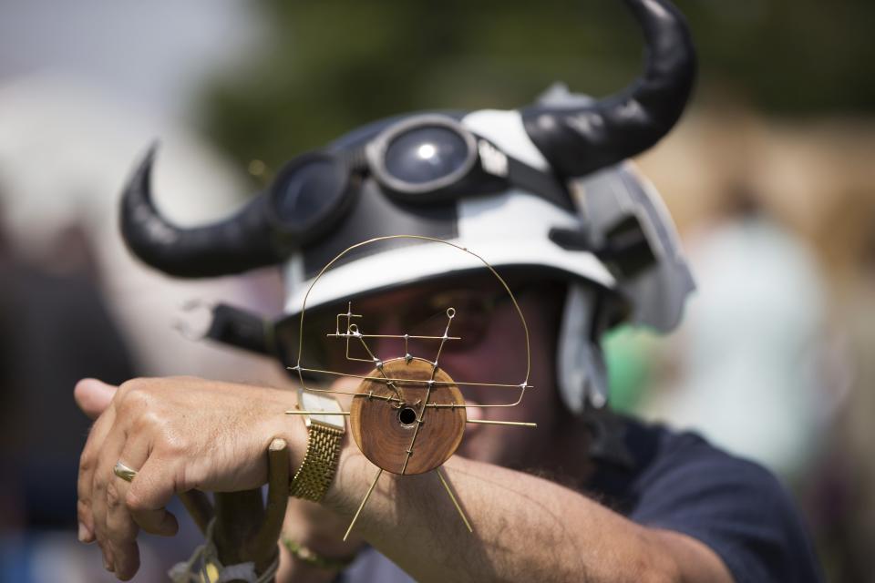 A competitor tests his customised pea shooter's sights before the start of the 2014 World Pea Shooting Championship in Witcham, southern England
