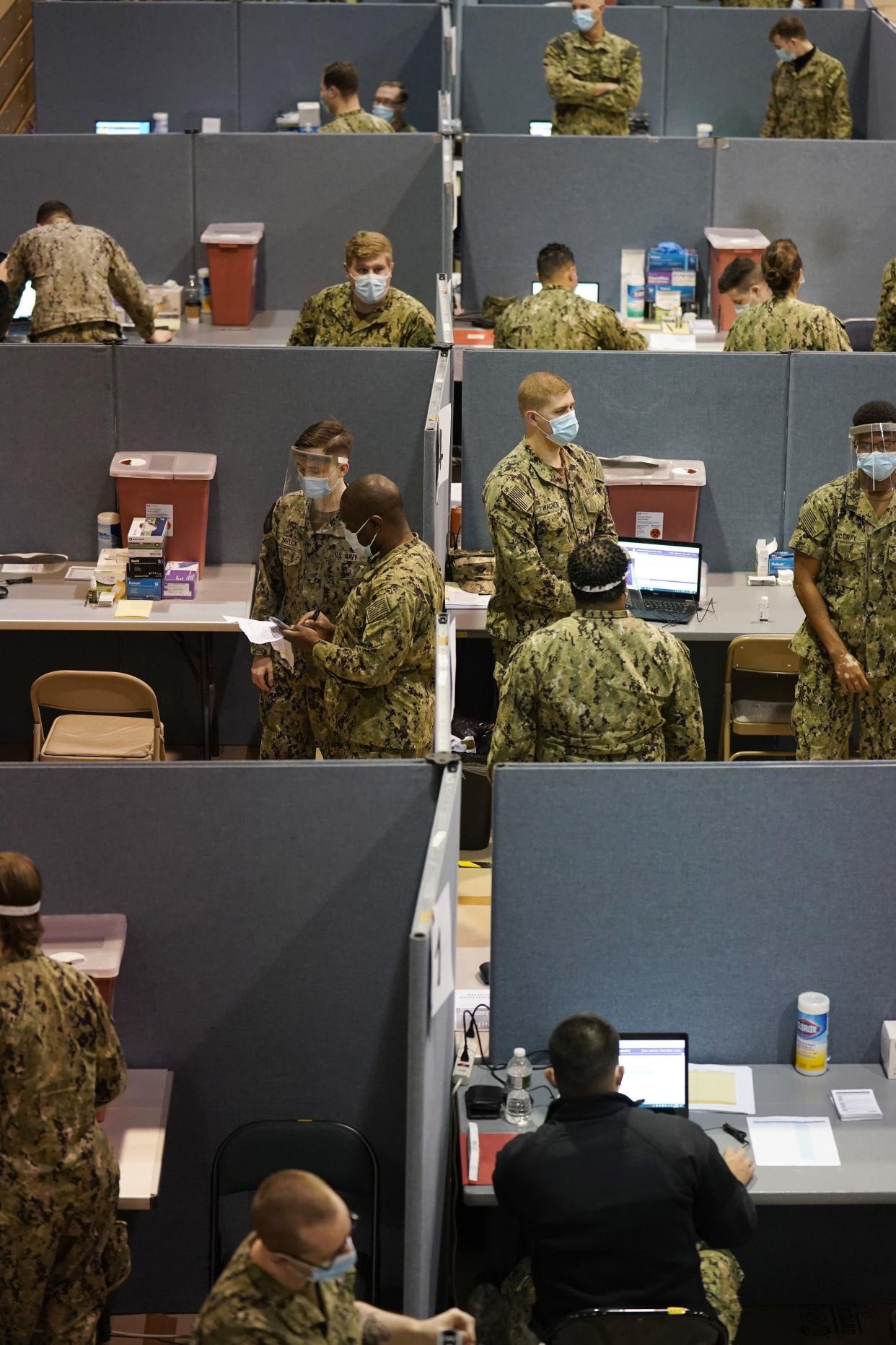 Primarily Navy personnel prepare for the opening of a mass vaccination site in the Queens borough of New York on Wednesday, Feb. 24, 2021. This FEMA-run site, along with another in Brooklyn, gives priority to local residents in an effort to equitably distribute the vaccine.