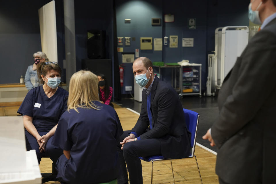 Britain's Prince William, center, speaks to staff and volunteers during his visit to the King's Lynn Corn Exchange Vaccination Centre in King's Lynn, Monday Feb. 22, 2021. (Arthur Edwards/Pool via AP)
