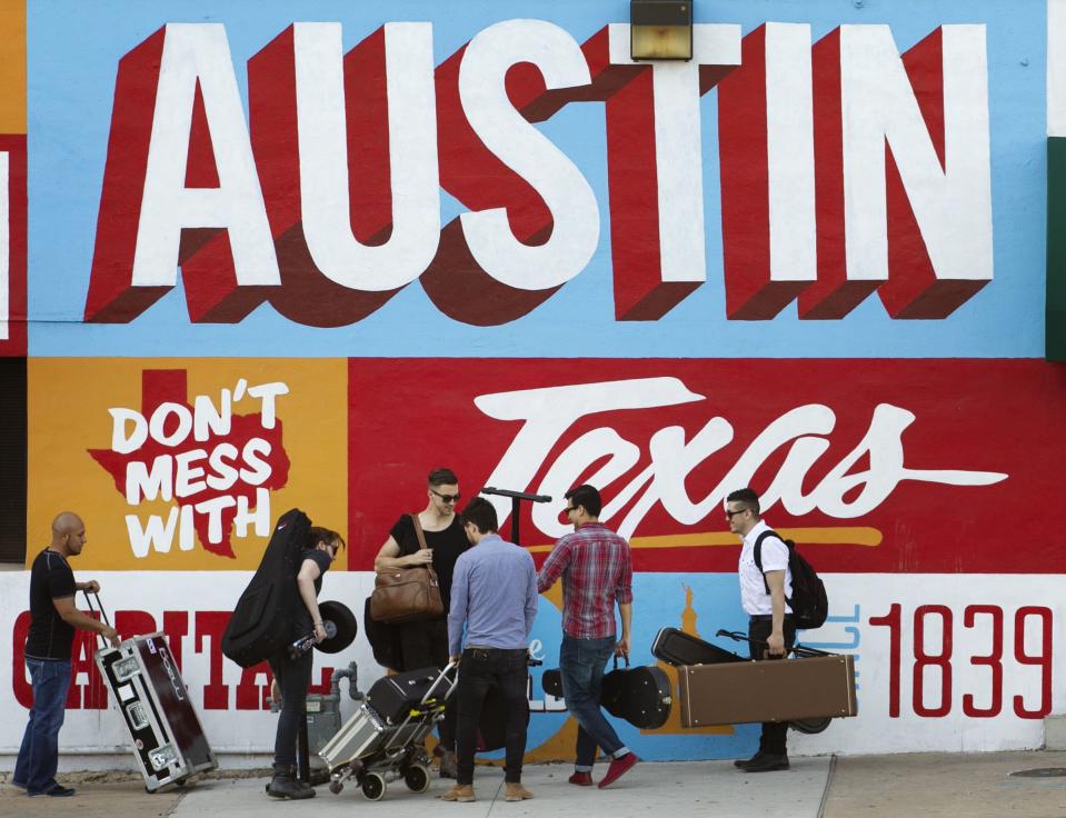 FILE - In this March 14, 2013 file photo, a band is on the move on the corner of Sixth Street and I-35 at South by Southwest in Austin, Texas. iTunes is putting its stamp on South by Southwest, piggybacking on the annual event hosted by the city of Austin, Texas, with its own music festival. The company said Wednesday, Feb. 19, 2014, it will debut its popular iTunes Festival, a free concert series held in London for the past seven years. While the London version is a 30-day event, the U.S. festival will feature five nights of rock, country, pop and hip-hop held at the ACL Live at the Moody Theater, where Austin City Limits is held. (AP Photo/Austin American-Statesman, Jay Janner) AUSTIN CHRONICLE OUT, COMMUNITY IMPACT OUT, MAGS OUT; NO SALES; INTERNET AND TV MUST CREDIT PHOTOGRAPHER AND STATESMAN.COM