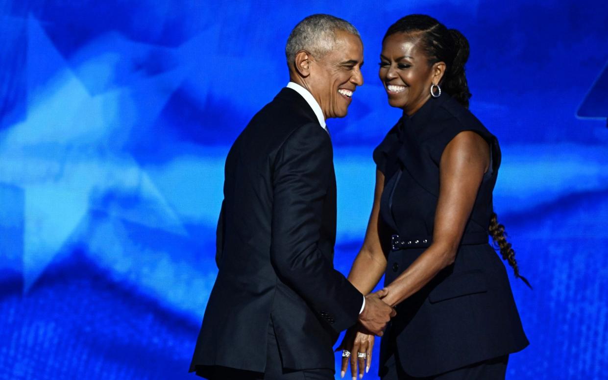 Former US President Barack Obama arrives onstage after his wife and former First Lady Michelle Obama introduced him