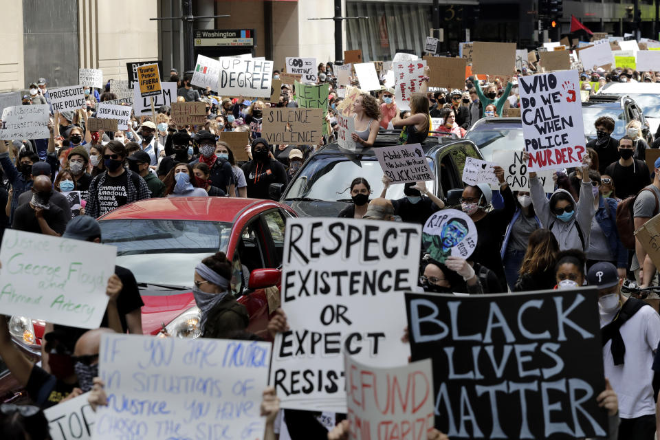 People hold signs as they march during a protest over the death of George Floyd in Chicago, Saturday, May 30, 2020. Protests across the country have escalated over the death of George Floyd who died after being restrained by Minneapolis police officers on Memorial Day, May 25. (AP Photo/Nam Y. Huh)