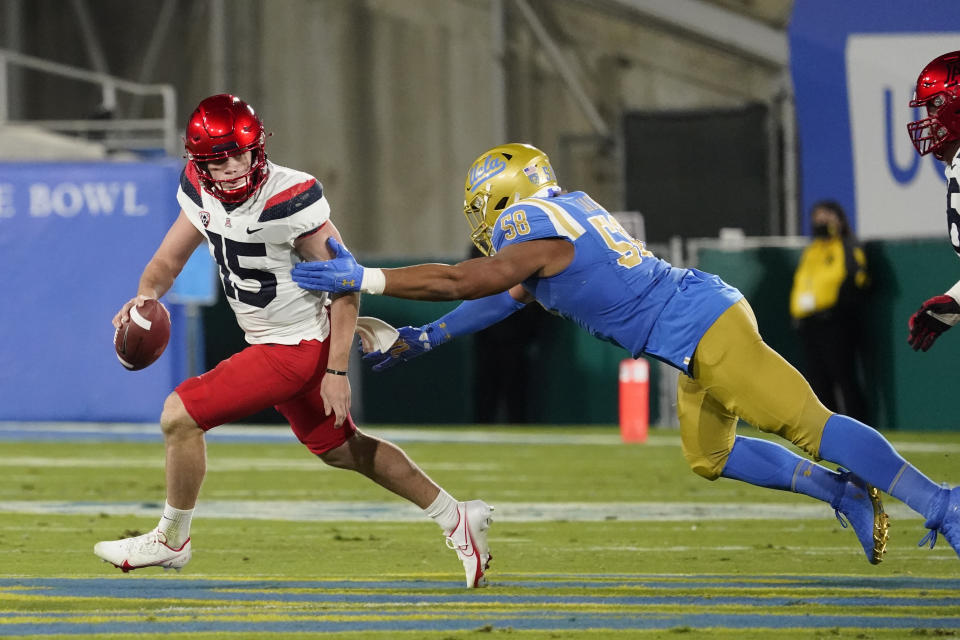 Arizona quarterback Will Plummer, left, is chased by UCLA defensive lineman Datona Jackson during the first half of an NCAA college football game Saturday, Nov. 28, 2020, in Pasadena, Calif. (AP Photo/Marcio Jose Sanchez)