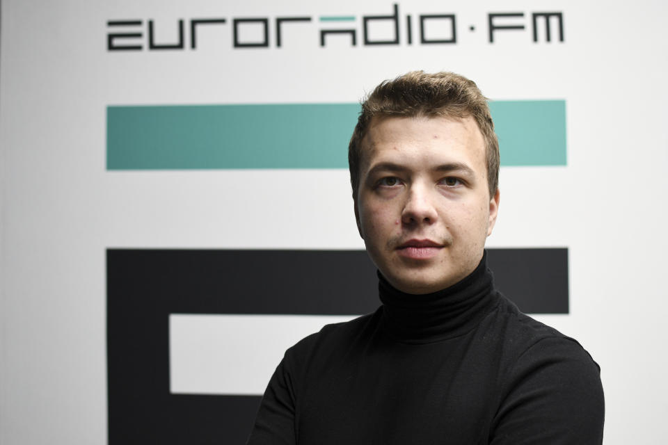 FILE - In this Nov. 17, 2019, file photo, provided by European Radio for Belarus, dissident journalist Raman Pratasevich poses for a photo in front of euroradio.fm sign in Minsk, Belarus. Pratasevich and another young journalist, Stsiapan Putsila, set up a channel on the Telegram messaging app called Nexta, which was used to organize demonstrations against authoritarian President Alexander Lukashenko. (Euroradio via AP, File)