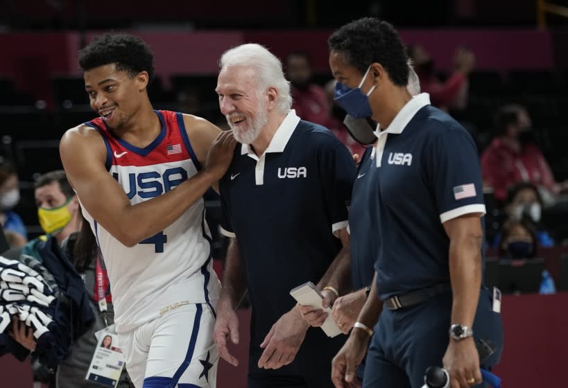 United States's Keldon Johnson (4), left, and head coach Gregg Popovich.