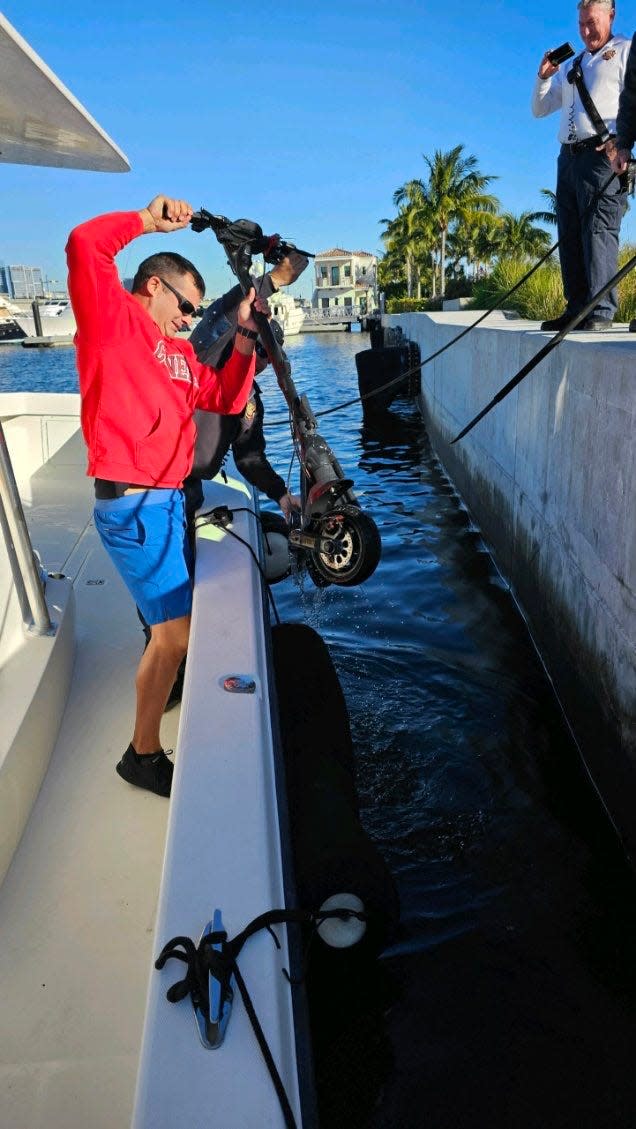Palm Beach police pull an electric scooter from the Intracoastal Waterway on Tuesday, Feb. 20. Police said the scooter was used by a man who broke into a Worth Avenue jewelry store and then fled from police to the water, where he ditched his scooter and jewels.