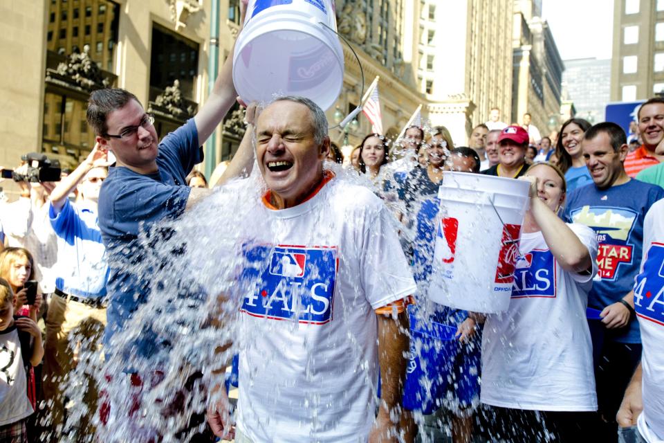 FILE - In this Aug. 20, 2014 file photo, Major League Baseball Commissioner-elect Rob Manfred participates in the ALS Ice-Bucket Challenge outside the organization's headquarters in New York. Pete Frates, who was stricken with amyotrophic lateral sclerosis, or ALS, and inspired the Ice Bucket Challege, died Monday, Dec. 9, 2019. He was 34. (AP Photo/Vanessa A. Alvarez, File)