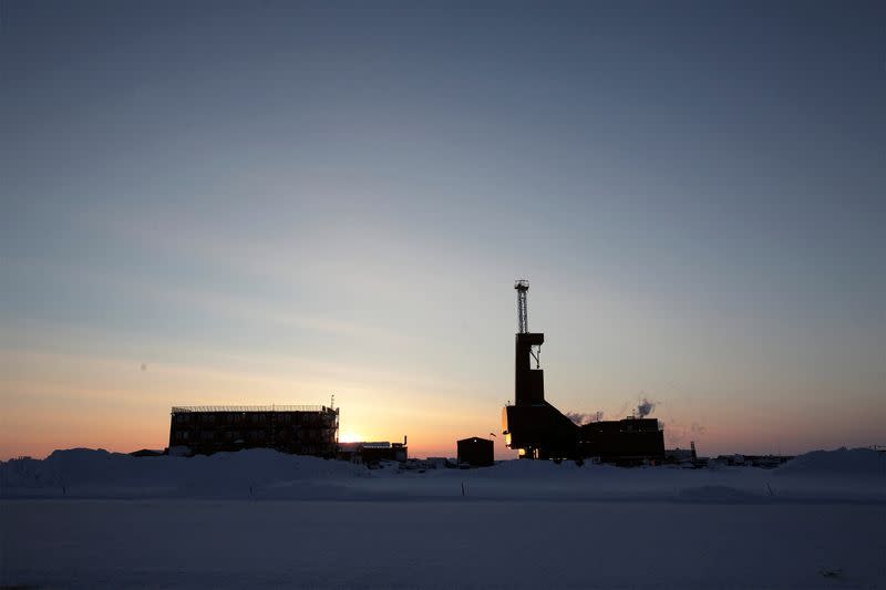 FILE PHOTO: The sun sets behind an oil drilling rig in Prudhoe Bay, Alaska