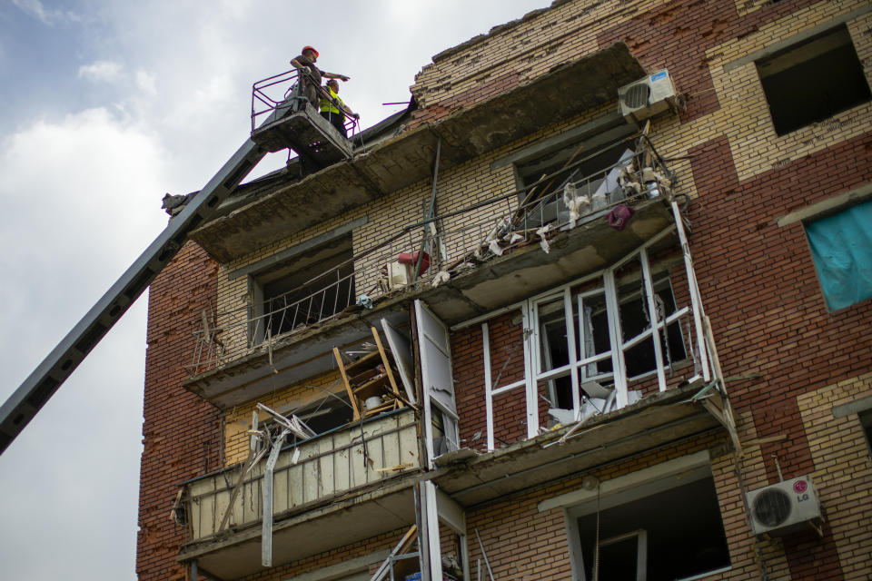 Rescue workers inspect an apartment building damaged in an overnight missile strike in Sloviansk, Ukraine, Tuesday, May 31, 2022. (AP Photo/Francisco Seco)