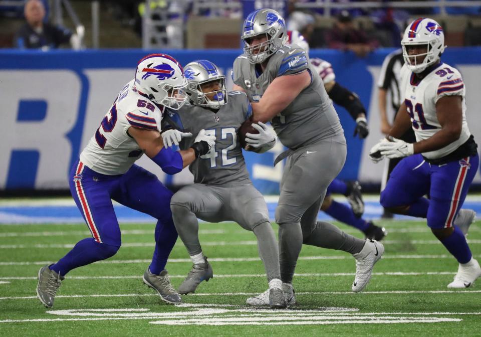 Detroit Lions center Frank Ragnow (77) blocks for running back Justin Jackson (42) who is tackled by Buffalo Bills linebacker A.J. Klein (52) during first-half action at Ford Field on Thursday, Nov. 24, 2022.