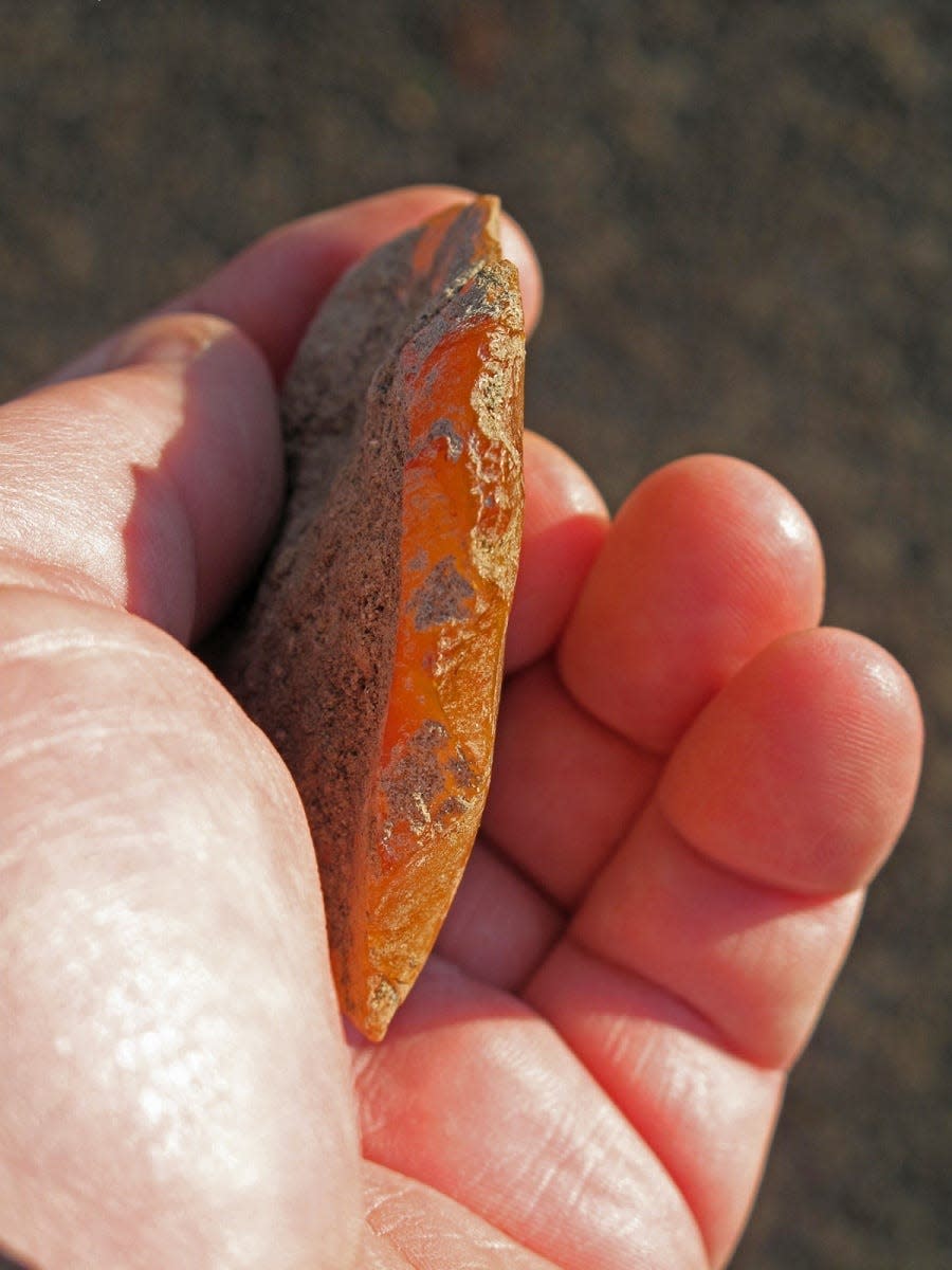 A team uncovered two finely crafted orange agate scrapers, one in 2012 with preserved bison blood residue and another in 2015 buried deeper in the ash, at Rimrock Draw Rockshelter.