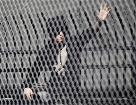 Pop singer Justin Bieber waves to fans as he leaves a jail after being released on bail in Miami, Florida January 23, 2014. REUTERS/Andrew Innerarity