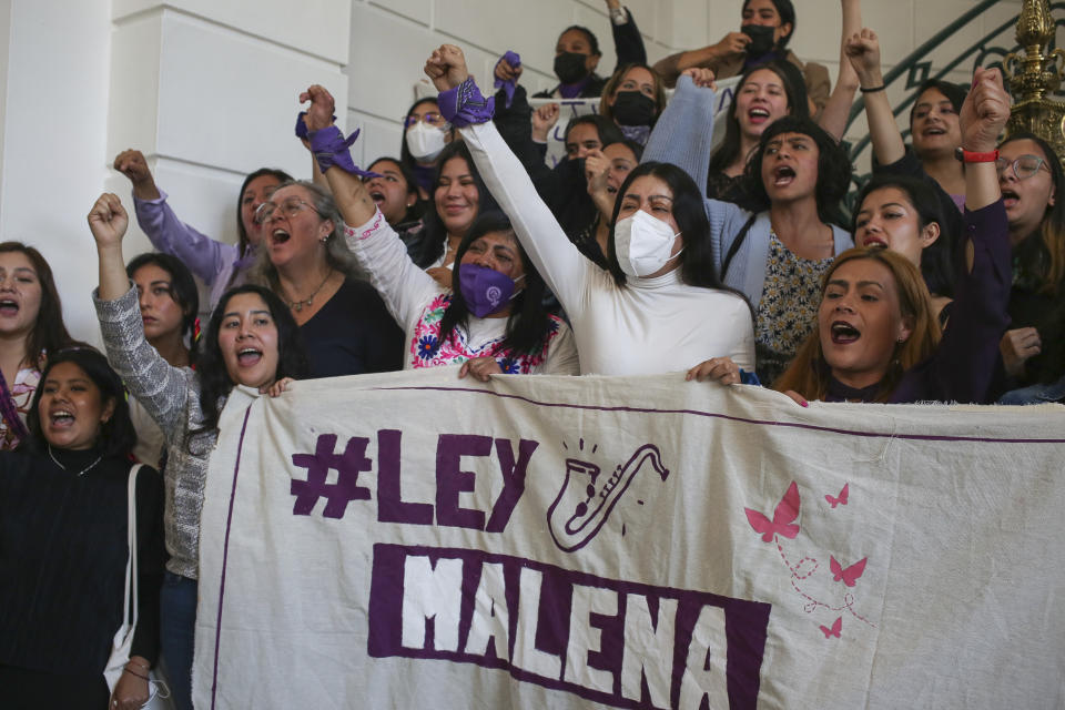 Acid attack survivors; Maria Elena Ríos, center, wearing a white face mask, and Elisa Xolalpa, left center, raise their fists in unison during a press conference concerning a proposed bill bearing Ríos' nickname, "Malena," at the Mexico City Congress, Tuesday, Jan. 31, 2023. The proposed bill would classify acid attacks as a distinct, serious crime equivalent to attempted homicide. Currently they are treated as simple assault or bodily injury. (AP Photo/Ginnette Riquelme)