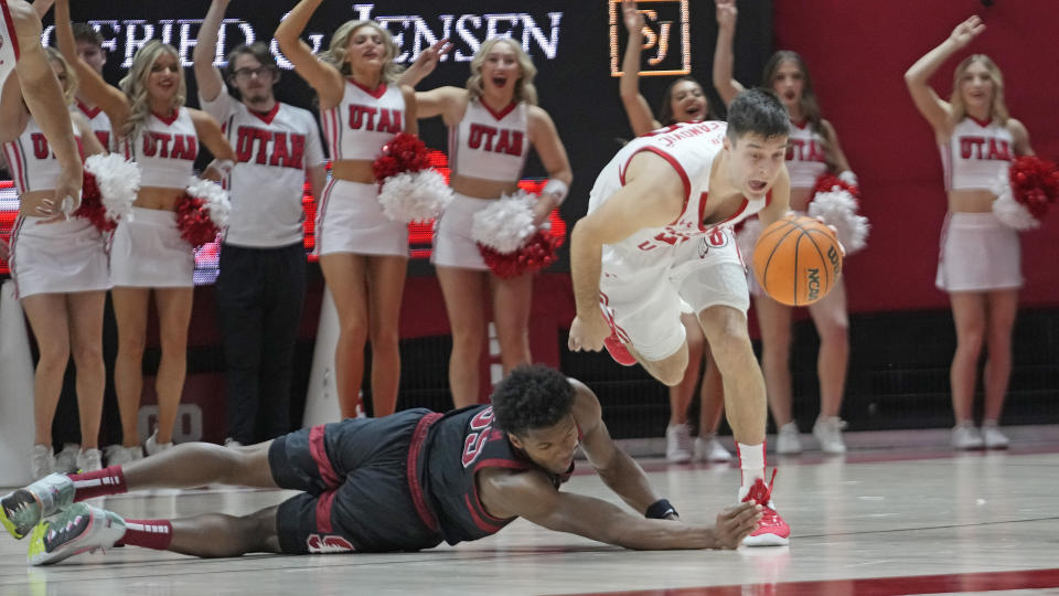 Stanford forward Harrison Ingram, left, and Utah guard Lazar Stefanovic, right, battle for the ball during the second half of an NCAA college basketball game Thursday, Feb. 2, 2023, in Salt Lake City. (AP Photo/Rick Bowmer)