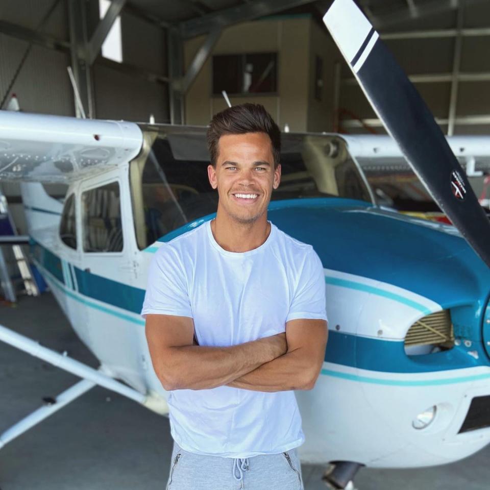 Bachelor Jimmy standing in front of a plane.