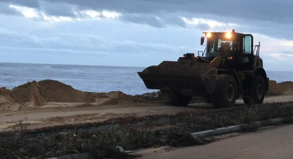 Heavy equipment makes its way along A1A in Flagler Beach on Thursday evening as crews work to repair damage to the road caused by Nicole.