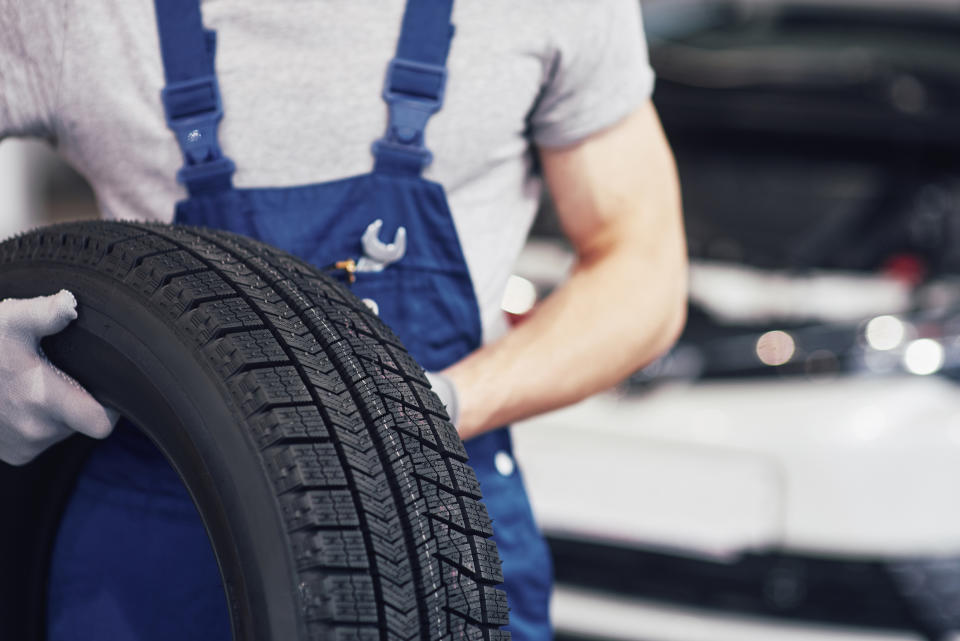 A person is carrying a tire