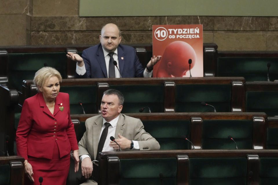 Dariusz Matecki, a conservative lawmaker in the Polish parliament, displays a poster showing a fetus and the words "10th week after conception," during a debate on liberalizing the abortion law , in Warsaw, Poland, on Thursday April 11, 2024. He also played the sound of a child's heartbeat through a microphone next to his chair. The traditionally Catholic nation has one of the most restrictive laws in Europe — but the reality is that many women terminate pregnancies at home with pills mailed from abroad. (AP Photo/Czarek Sokolowski)