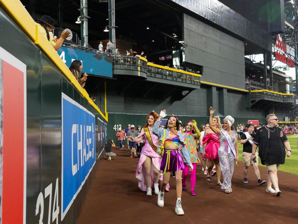 People participating in the Pride Walk stroll on the warning track before the game against the Chicago White Sox on June 14, 2024 at Chase Field in Phoenix.