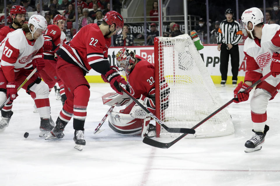 Detroit Red Wings center Oskar Sundqvist (70) and defenseman Filip Hronek (17), right, try to score against Carolina Hurricanes defenseman Brett Pesce (22) and goaltender Antti Raanta (32) during the first period of an NHL hockey game Thursday, April 14, 2022, in Raleigh, N.C. (AP Photo/Chris Seward)