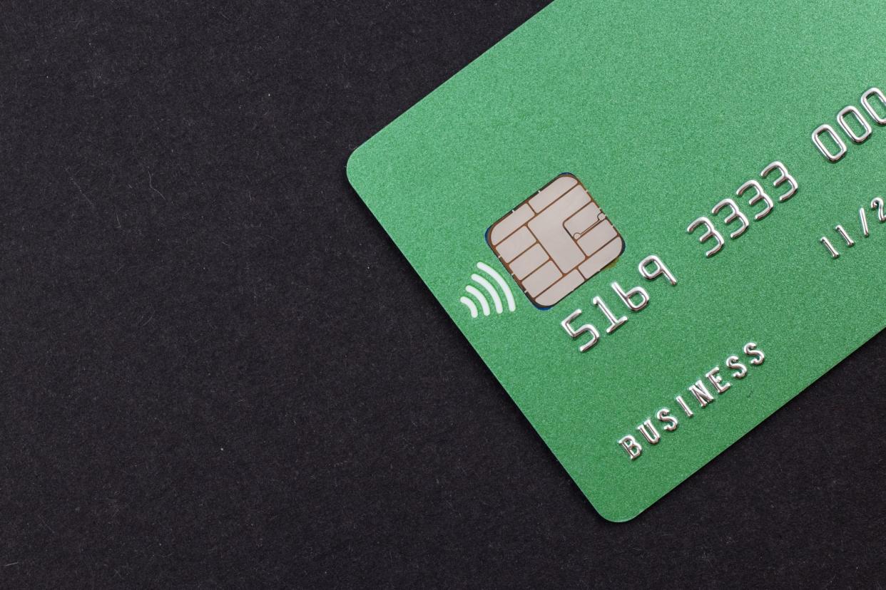 Green credit card on dark background