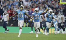 Los Angeles Chargers defensive back Adrian Phillips (31) and free safety Derwin James (33) celebrate after a successful defensive play near the end of the second half of an NFL football game against Tennessee Titans at Wembley stadium in London, Sunday, Oct. 21, 2018. Los Angeles Chargers won the match 20-19. (AP Photo/Matt Dunham)