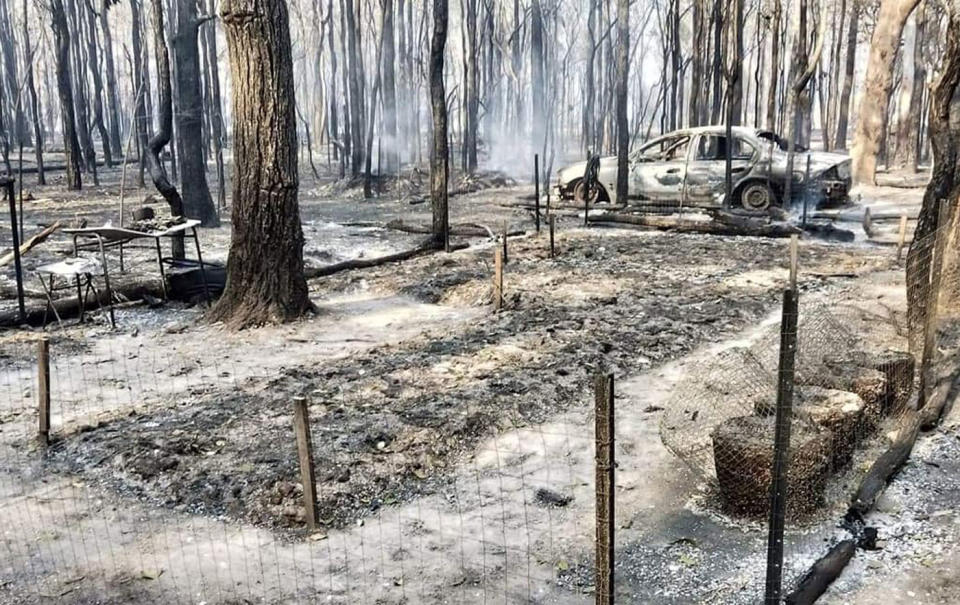 A smouldering property with a destroyed car at West Bungawalbin