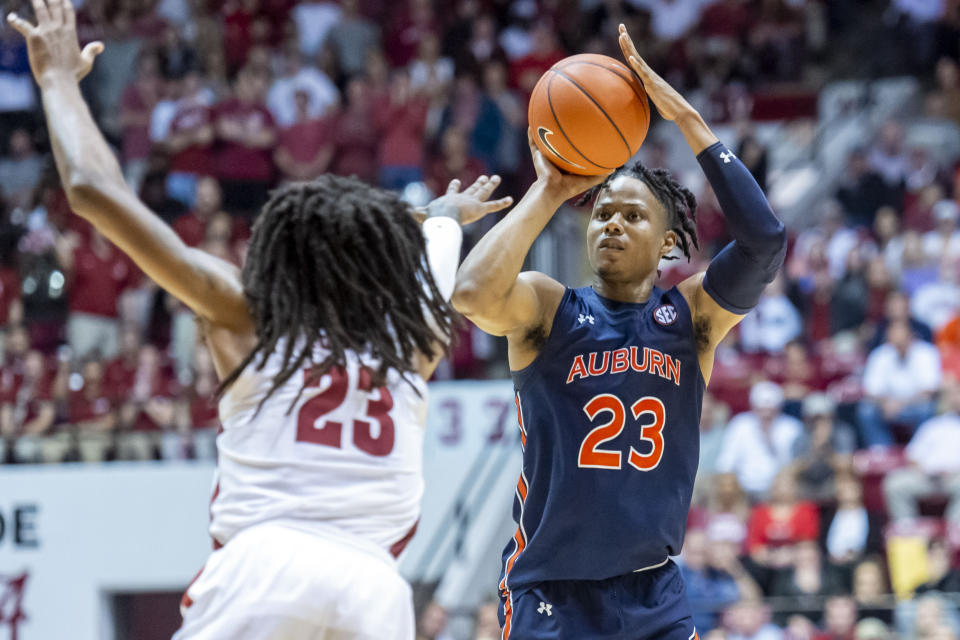 Auburn forward Isaac Okoro (23) shoots a three as Alabama guard John Petty Jr. (23) arrives late to defend the shot during the first half of an NCAA college basketball game, Wednesday, Jan. 15, 2020, in Tuscaloosa, Ala. (AP Photo/Vasha Hunt)