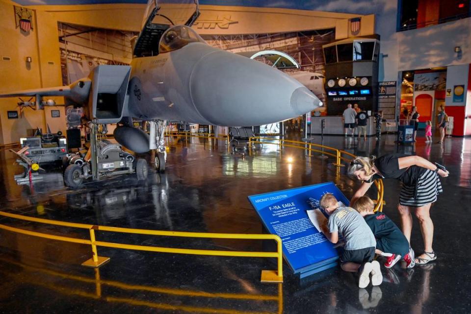 Becky Zweig helps her grandson JB Carter, left and his friend Caleb Daniel with a scavenger hunt in front of the F-15 on display at the Museum of Aviation in Warner Robins.