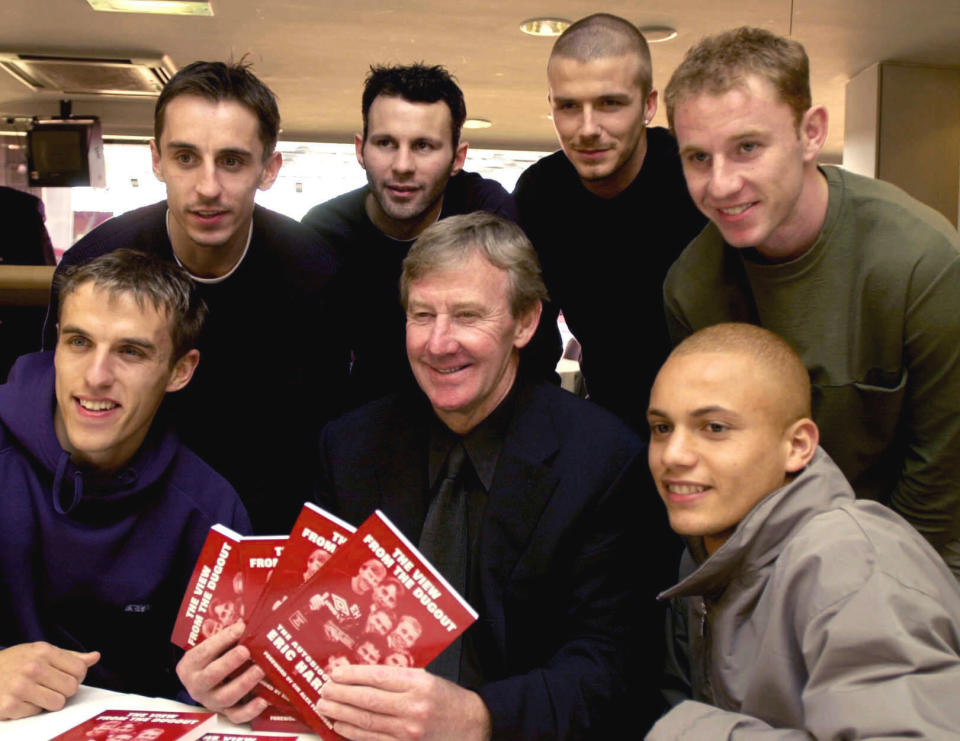 FILE - In this March 1, 2001 file photo, Eric Harrison, centre, poses for a photo with Manchester United players from left, Gary Neville, Phil Neville, Ryan Giggs, David Beckham, Nicky Butt and Wes Brown during his book launch, at Old Trafford, in Manchester, England. Harrison, the Manchester United youth team manager who launched the career of David Beckham as part of the renowned group of "Class of 92" players, has died, it was reported on Thursday, Feb. 14, 2019. (Rui Vieira/PA via AP, File)