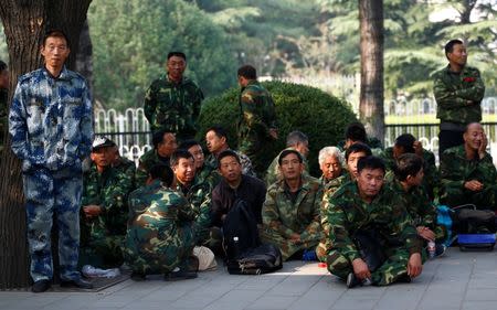 Uniformed people take part in a protest outside the Bayi Building, a major Chinese military building in Beijing, China, October 11, 2016. REUTERS/Thomas Peter