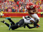 Kansas City Chiefs tight end Travis Kelce (87) tries to vault past Jacksonville Jaguars cornerback Jalen Ramsey (20) and linebacker Telvin Smith, rear, during the first half of an NFL football game in Kansas City, Mo., Sunday, Oct. 7, 2018. (AP Photo/Charlie Riedel)