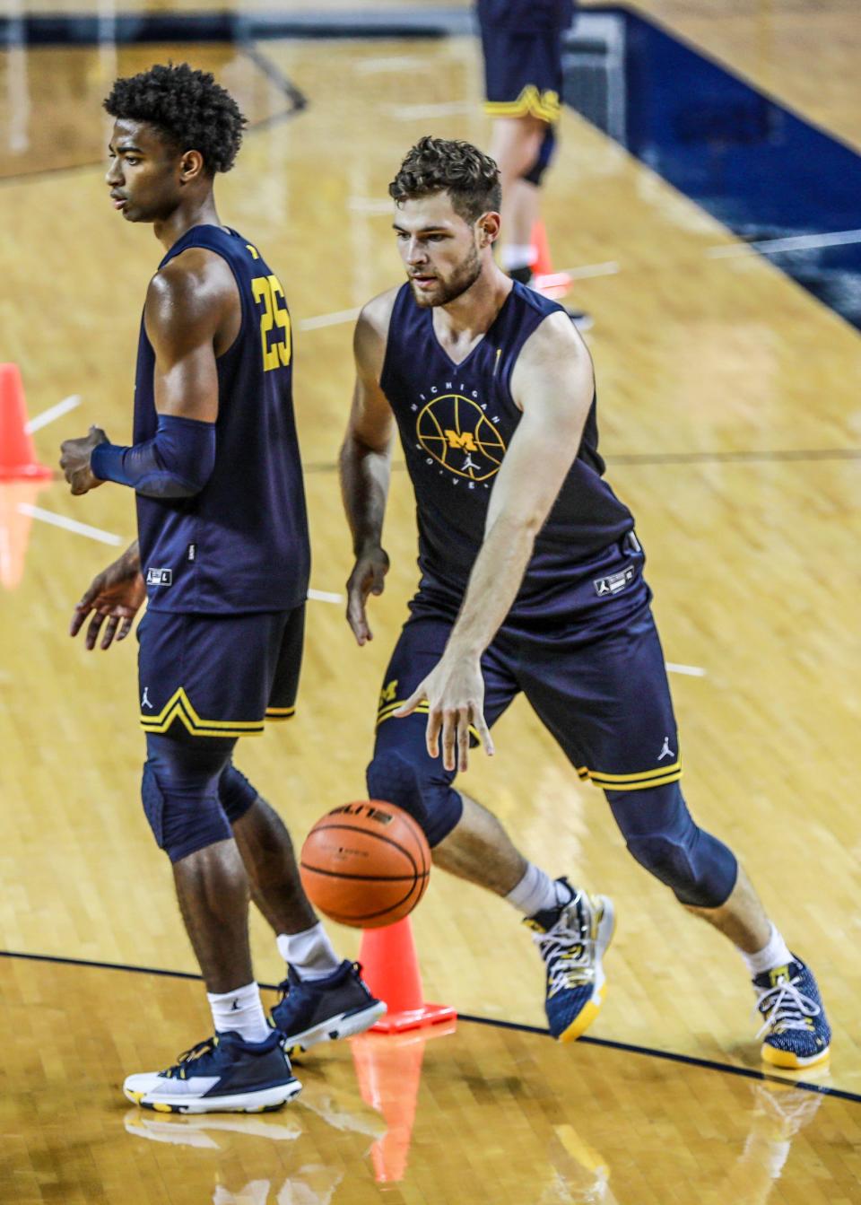 Michigan basketball center Hunter Dickinson, right, runs a drill with guard Jace Howard during media day Oct. 15, 2021 at Crisler Center in Ann Arbor.